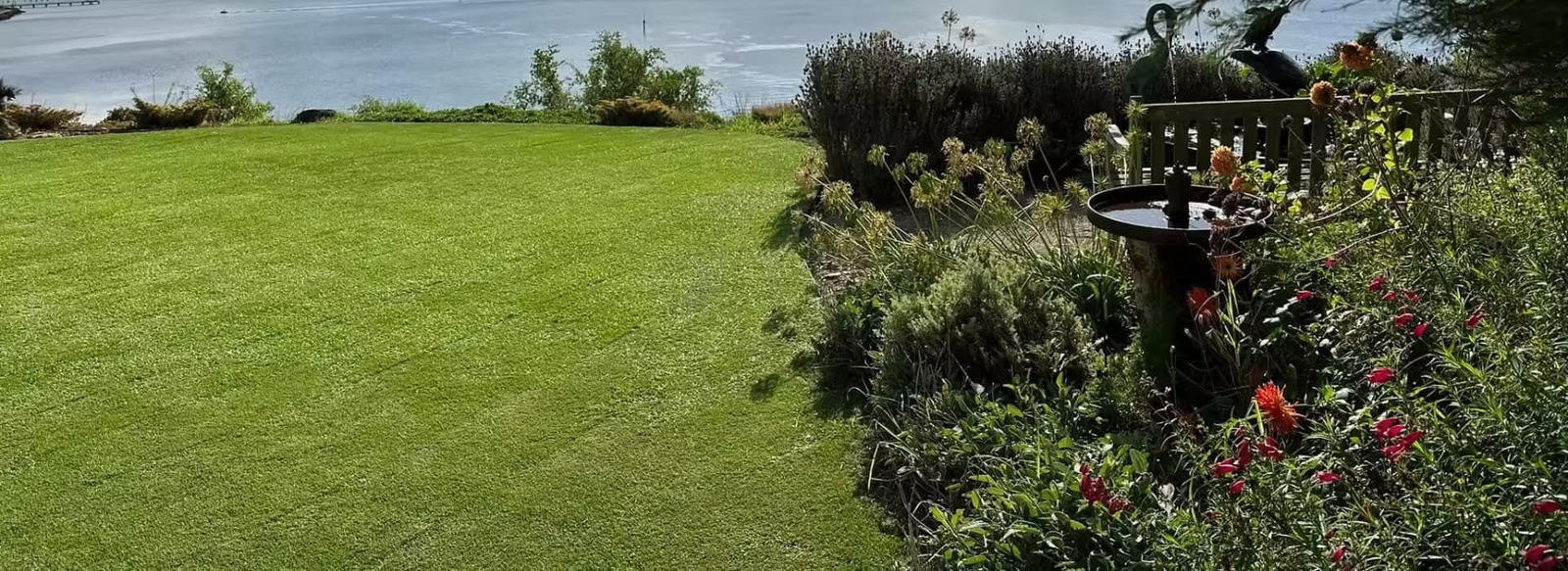 Lawn in the foreground overlooking an open landscape with distant hills and a scenic natural view.