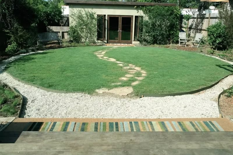 Circular UC Verde buffalograss lawn surrounded by gravel pathways and stepping stones.